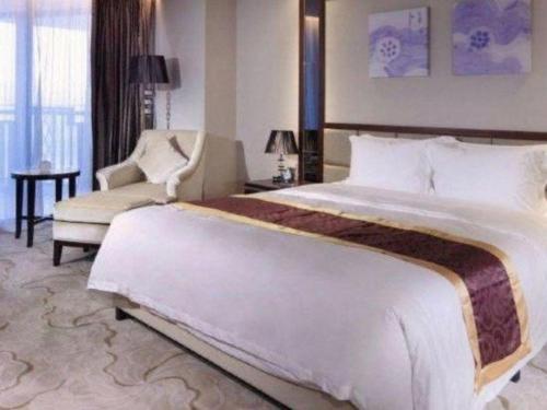 a hotel room with a large bed and a chair at SUN Yat-sen university Hotel and Conference Centre in Guangzhou