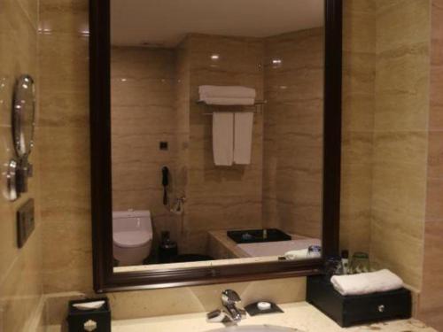 a bathroom with a mirror and a sink and a tub at SUN Yat-sen university Hotel and Conference Centre in Guangzhou