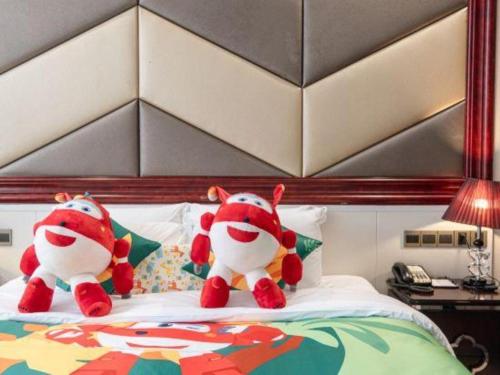two stuffed animals sitting on top of a bed at SUN Yat-sen university Hotel and Conference Centre in Guangzhou