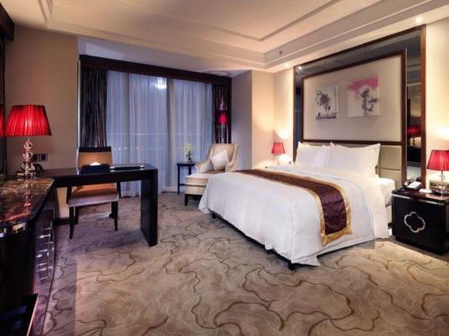 a hotel room with a large bed and a desk and a desk at SUN Yat-sen university Hotel and Conference Centre in Guangzhou