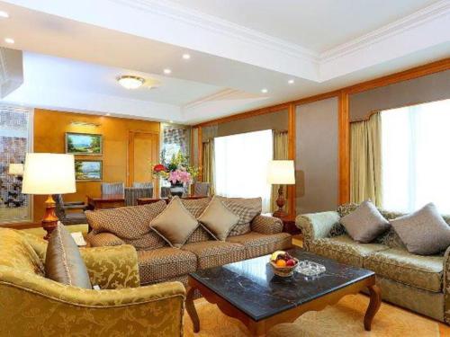 a living room with couches and a coffee table at Regency Hotel in Shantou