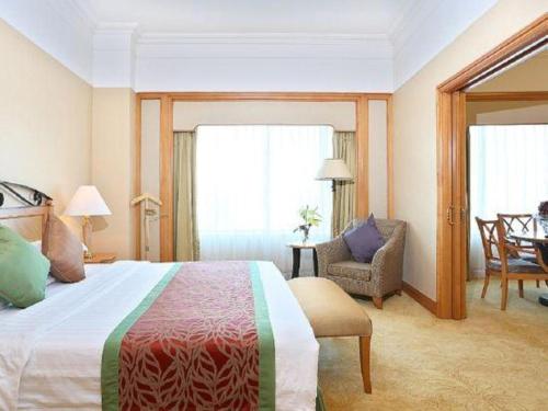 a hotel room with a bed and a chair at Regency Hotel in Shantou