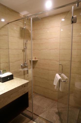 a bathroom with a shower with a glass door at SUN Yat-sen university Hotel and Conference Centre in Guangzhou