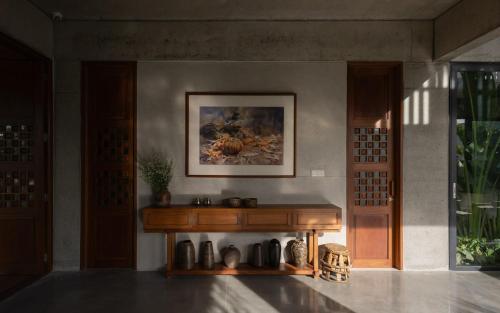 a room with a table and a painting on the wall at Private 4 bedrooom Nongnia Beach Villas in Tân Thành (1)