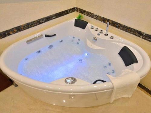 - une grande baignoire blanche dans la chambre dans l'établissement GreenTree Eastern Zigong Huashang International City Huichuan Road Hotel, à Shuping