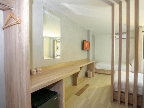 une chambre avec un lit et un bureau avec un miroir dans l'établissement B2 Buriram Boutique and Budget Hotel, à Ban Khok Wat