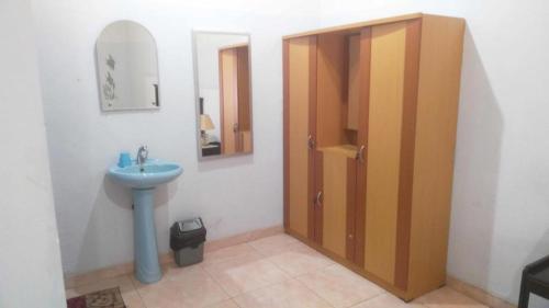 a bathroom with a sink and a wooden door at Avicenna Hotel in Palangkaraya