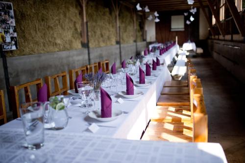 una larga fila de mesas con platos y vasos en Na Zvonici, en Paseky nad Jizerou