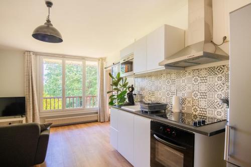 une cuisine avec des armoires blanches et un four à plaques de cuisson dans l'établissement 36 m2 2-room apartment, parking, fiber internet, near metro, Literie Bultex, à Ramonville-Saint-Agne