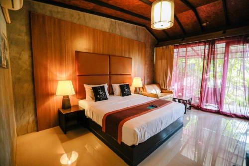 a bedroom with a large bed in a room at Panwana Resort in Rayong