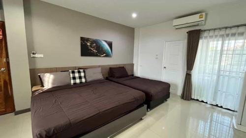 a bedroom with a large bed and a window at Tanban Mansion in Surin