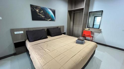 a bedroom with a large bed and a red chair at Tanban Mansion in Surin