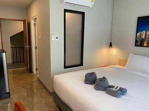 a bedroom with a bed with towels on it at Tanban Mansion in Surin