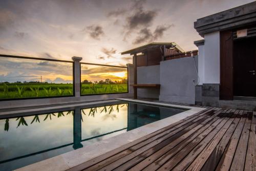 a house with a swimming pool and a wooden deck at Om Villas Kedungu in Tanah Lot