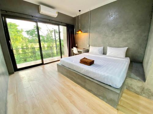 a bedroom with a white bed and a large window at Boxotel in Maha Sarakham