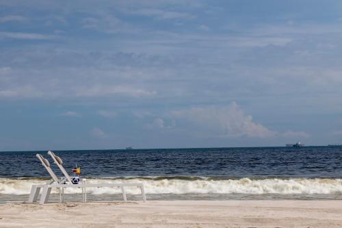 a pair of chairs sitting on the beach at Hilton Salalah Resort in Salalah