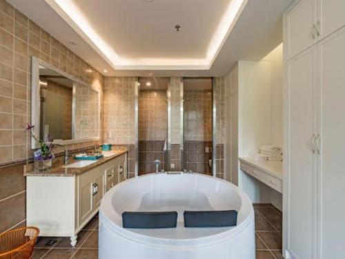 Un baño grande con bañera y lavabo. en Beijng Chestnut Valley Hotel, en Sanduhe
