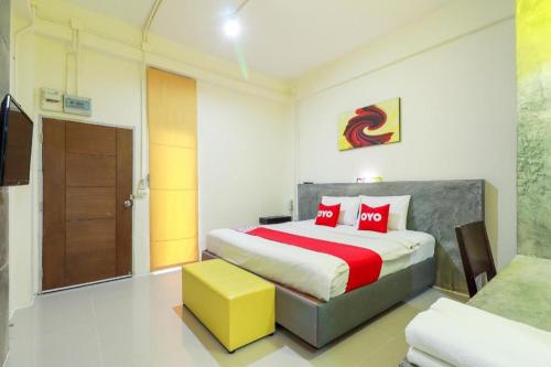 a bedroom with a large bed with red pillows at OYO 412 7 Days Hotel in Chiang Mai