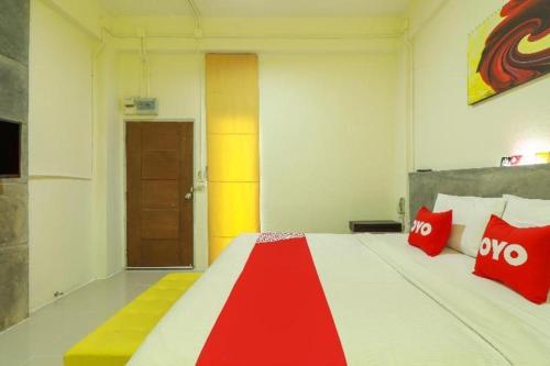 a bedroom with a large bed with red pillows at OYO 412 7 Days Hotel in Chiang Mai