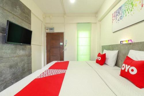 a bedroom with a large bed with red pillows at OYO 412 7 Days Hotel in Chiang Mai