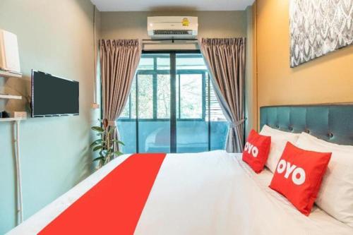 a bedroom with a large bed with red pillows at OYO 726 Sookjai Cafe and Hostel in Chiang Mai