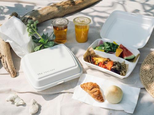 une table avec deux boîtes à lunch et de la nourriture dessus dans l'établissement The Rescape, à Île Miyako