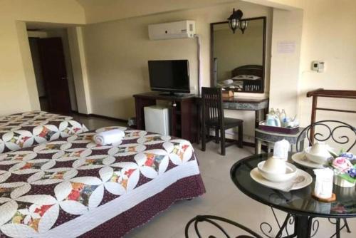 a bedroom with a bed and a table and a mirror at OYO 903 Madame Kim Hostel in Lampang