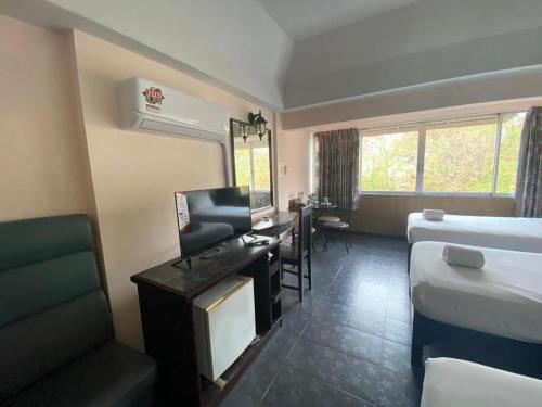 a hotel room with a bed and a desk and a bedroom at OYO 903 Madame Kim Hostel in Lampang