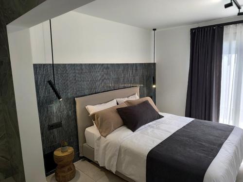 a bedroom with a bed with a black and white headboard at Valantina's & Mannouel Lardos Luxury Villas in Lardos