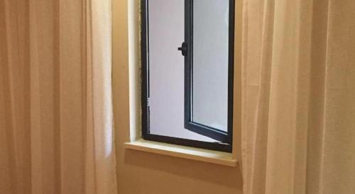 a window with a black frame in a bathroom at 7 Days Premium Nanjing Gaochun Beiling Road Branch in Gaochun