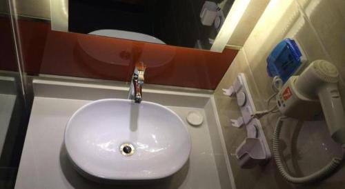 a bathroom with a white sink and a mirror at 7 Days Premium Nanjing Gaochun Beiling Road Branch in Gaochun