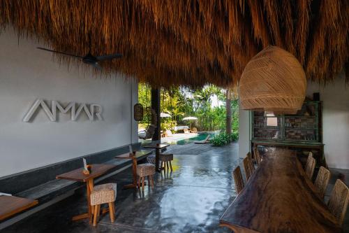 a restaurant with tables and chairs and a umbrella at Amar Boutique Hotel in Canggu