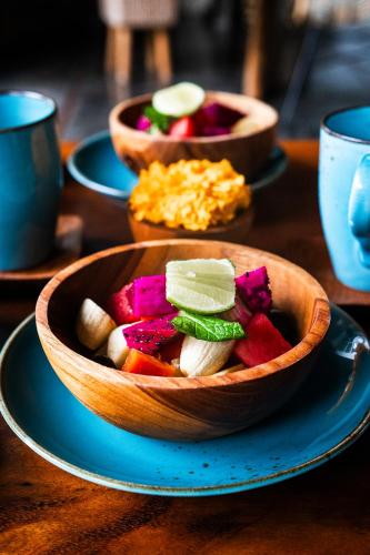 a wooden bowl of food on a table at Amar Boutique Hotel in Canggu