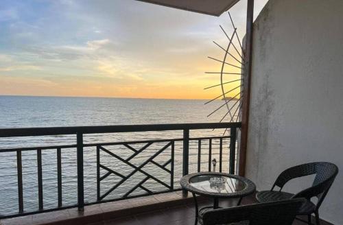 a balcony with a table and chairs and the ocean at Oceanwhite Homestay Corus in Port Dickson
