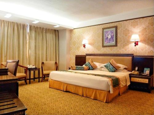 una habitación de hotel con una cama grande y un piano en Landmark International Hotel Nanwan, en Zhuhai
