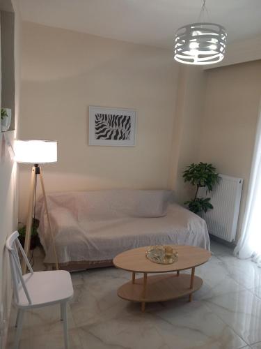 ein Schlafzimmer mit einem Bett, einem Tisch und einem Stuhl in der Unterkunft Eva's Sweet Home in Thessaloniki