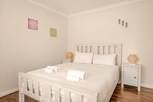 a bedroom with a white bed with two towels on it at Spindrift Escape in Dunsborough