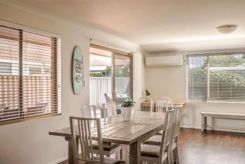 a dining room with a wooden table and chairs at Spindrift Escape in Dunsborough