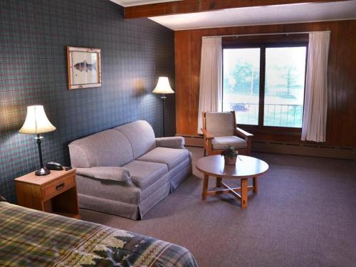 a hotel room with a couch and a chair at Birchwood Inn in Harbor Springs