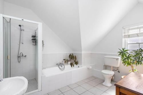 Un baño blanco con inodoro y lavabo. en Summerville Beach Loft by Host Agents, en Ciudad del Cabo