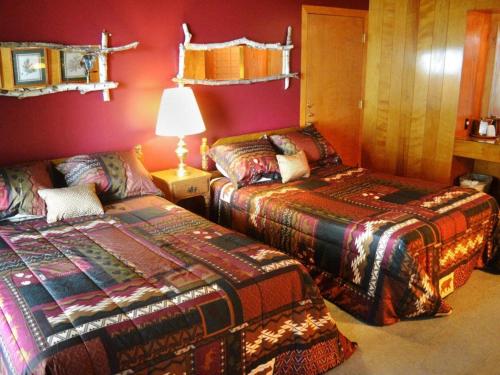 two beds in a room with red walls at Birchwood Inn in Harbor Springs
