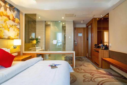 a hotel room with a bed and a bathroom at Jinjiang Metropolo Hotel - Taizhou Wanda Plaza in Taizhou