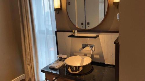 a bathroom with a sink and a mirror at Jinjiang Metropolo Hotel - Taizhou Wanda Plaza in Taizhou