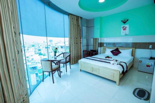 a bedroom with a bed and a table with chairs at Eden Hotel Sai Gon in Ho Chi Minh City