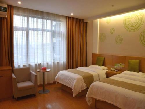 a hotel room with two beds and a chair and a window at GreenTree Inn Ningbo Ninghai Beidou North Road Express Hotel in Shang-ts'un