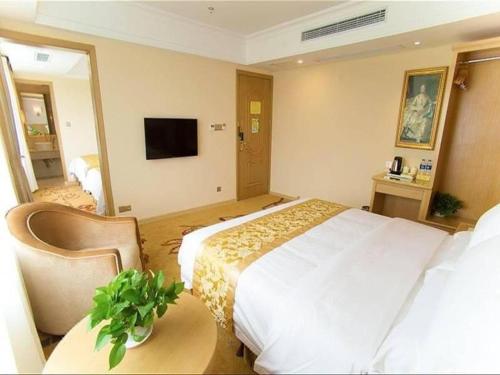 a hotel room with a large bed and a tv at Vienna 3 Best Shanghai Baoshan Fengxiang Road in Shanghai