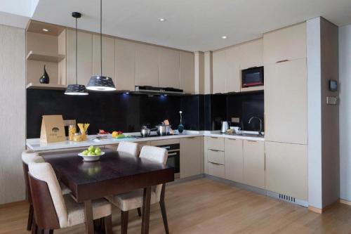 a kitchen with a table and chairs in a room at Shama Daqing Heilongjiang in Daqing