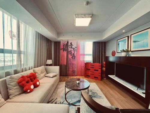 a living room with a white couch and a television at Shama Daqing Heilongjiang in Daqing