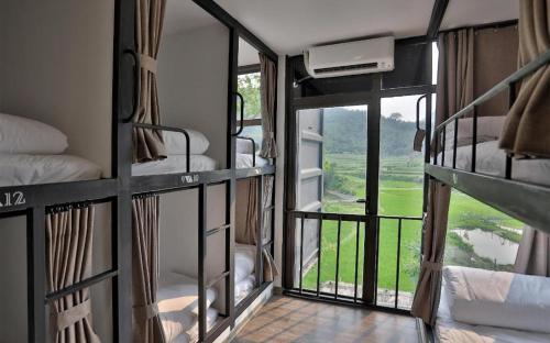 a room with bunk beds with a view of a field at Pu Luong Hostel in Ải Hạ