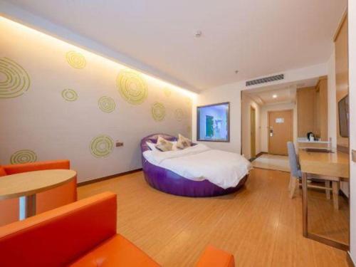 a hotel room with a large bed and a table at GreenTree Inn Nantong University Industrial Expo City Express Hotel in Nantong